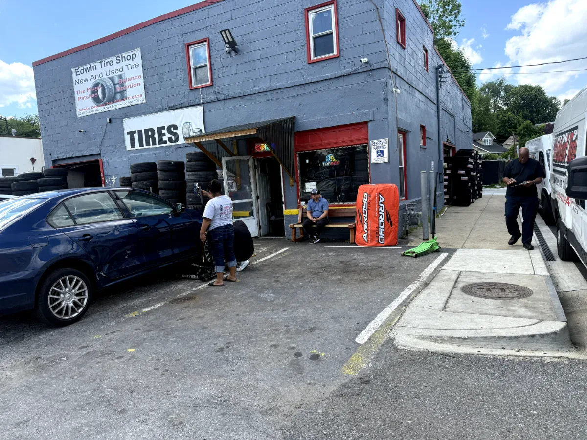 Real Edwin Tire Shop storefront with customers and tire stacks